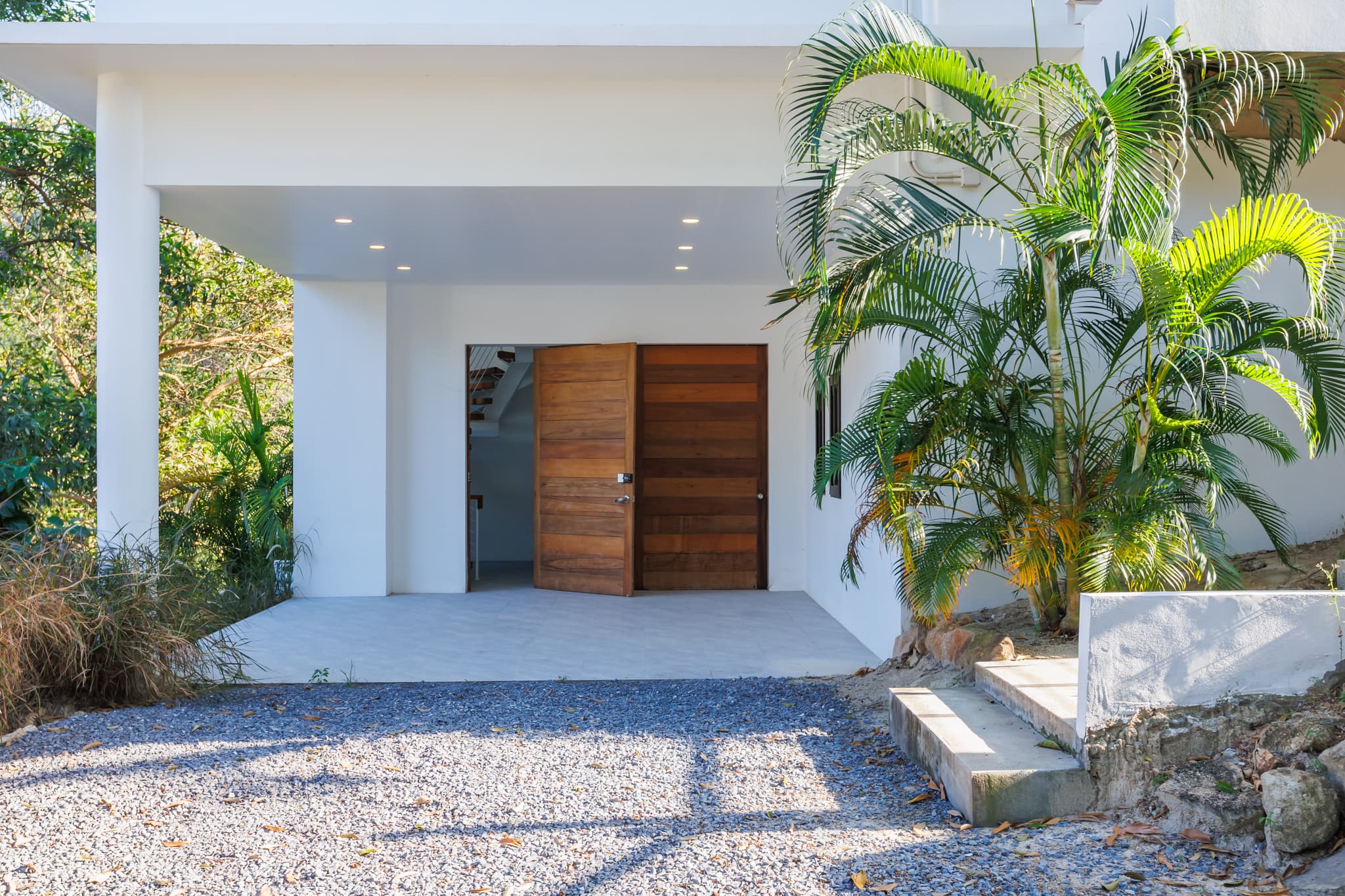 Villa entrance with wooden double doors and palms, Koh Phangan