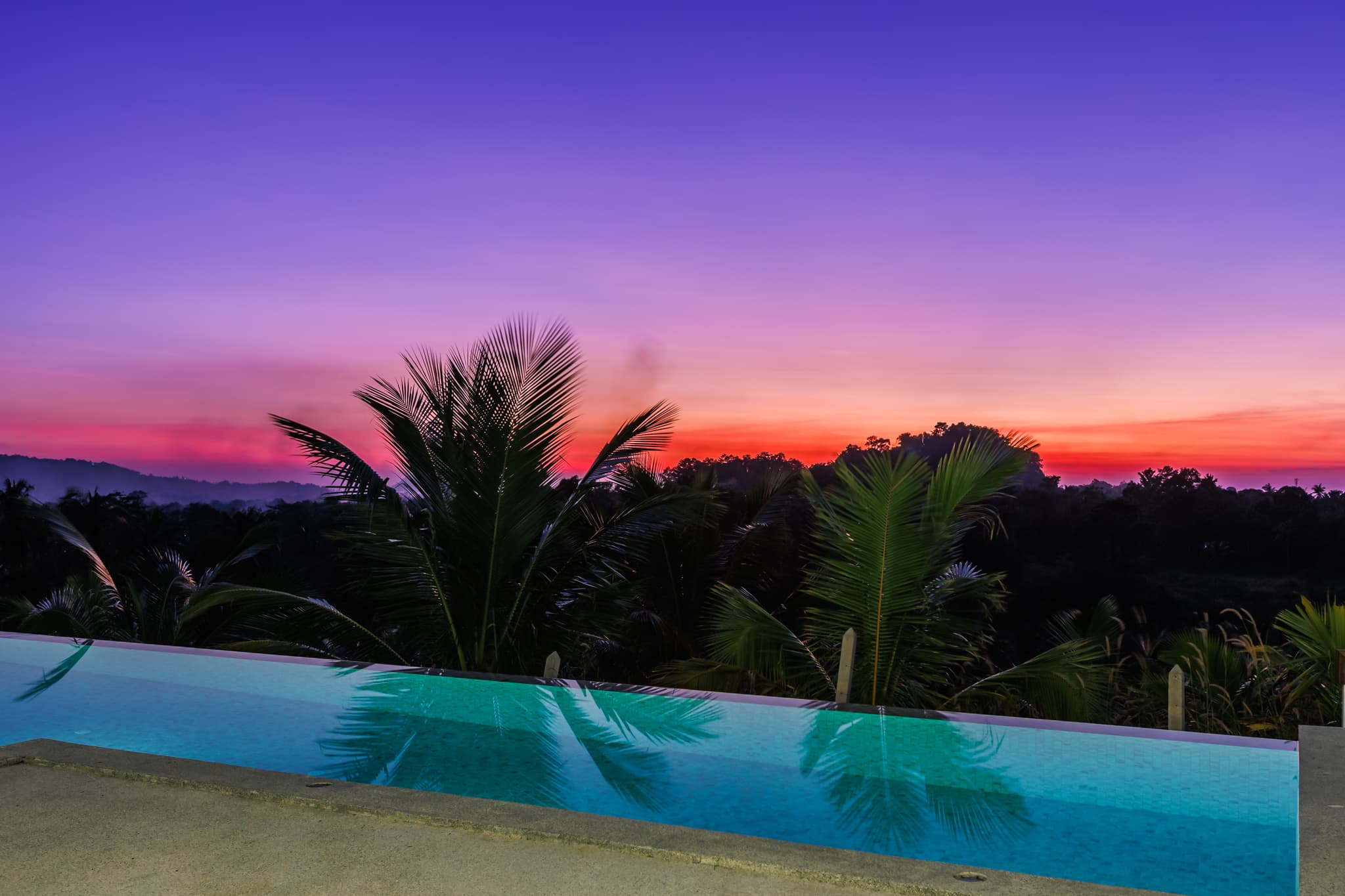 Infinity pool edge with palm silhouettes at sunset at Villa Sekoya, Hin Kong Bay, Koh Phangan